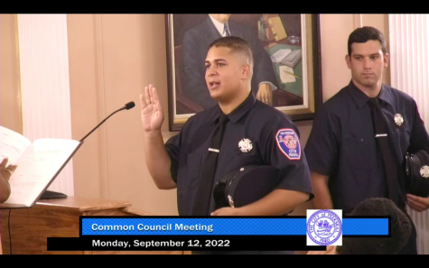 Marcos Suarez takes the oath to be a firefighter in Peekskill while Rocco Picciano looks on at City Hall Monday night. 