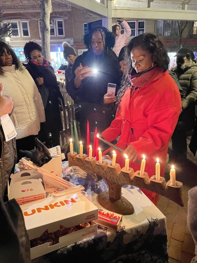 Incoming President of the Peekskill NAACP Priscilla Augustin lights a candle on the Kinara. 