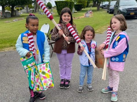 Members of the West Lakeland Girl Scouts from left, Daisy Ava Martinez, Brownie Anna Kucher, Sprout Athena Dalessandro and Daisy Astrid Dalessandro put out flags at cemetery on Saturday. (Photo by Kelly Sorrentino) 