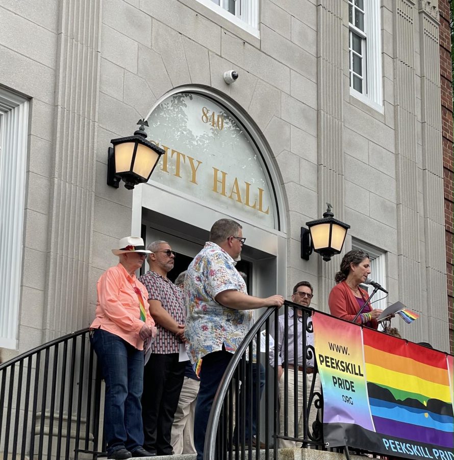 Assemblywoman Dana Levenberg speaks to the crowd gathered for Peekskills raising of the Pride flag. To her left is Councilman Brian Fassett and behind him in the white hat is Carla Rae Johnson who designed the flag.  (Photo by Regina Clarkin) 