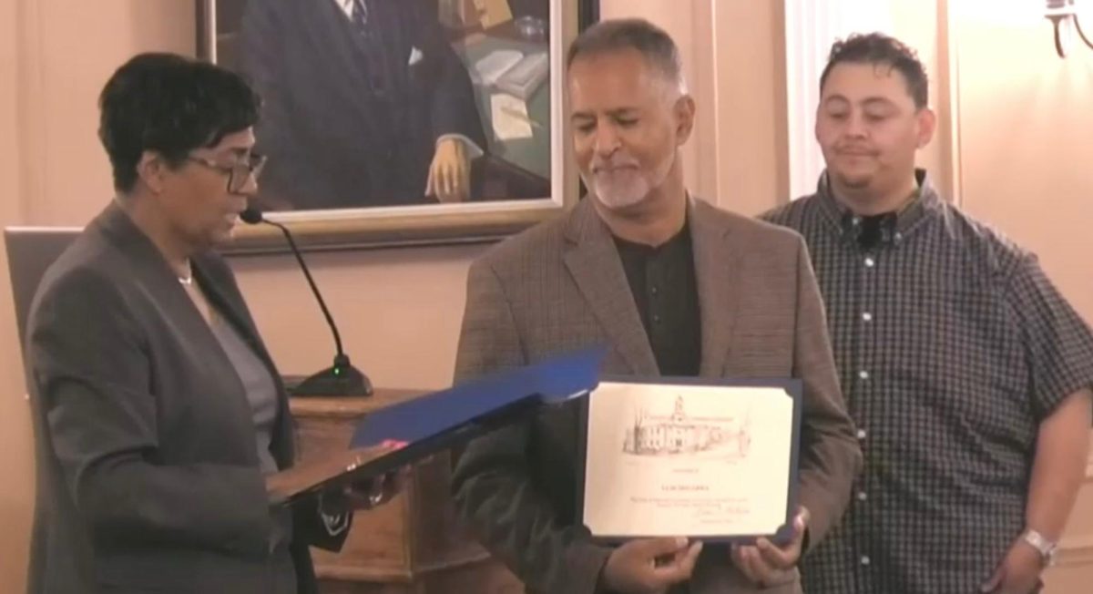 Mayor+Vivian+McKenzie+reading+from+a+proclamation.+Holding+certificate+is+Luis+Segarra+and+Roy+Escobar+behind+him.+