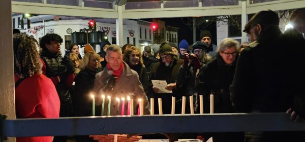 Chuck Newman lighting one of the 15 candles symbolizing the dispelling of darkness from antisemitism and racism. (All photos by Dave Mueller) 