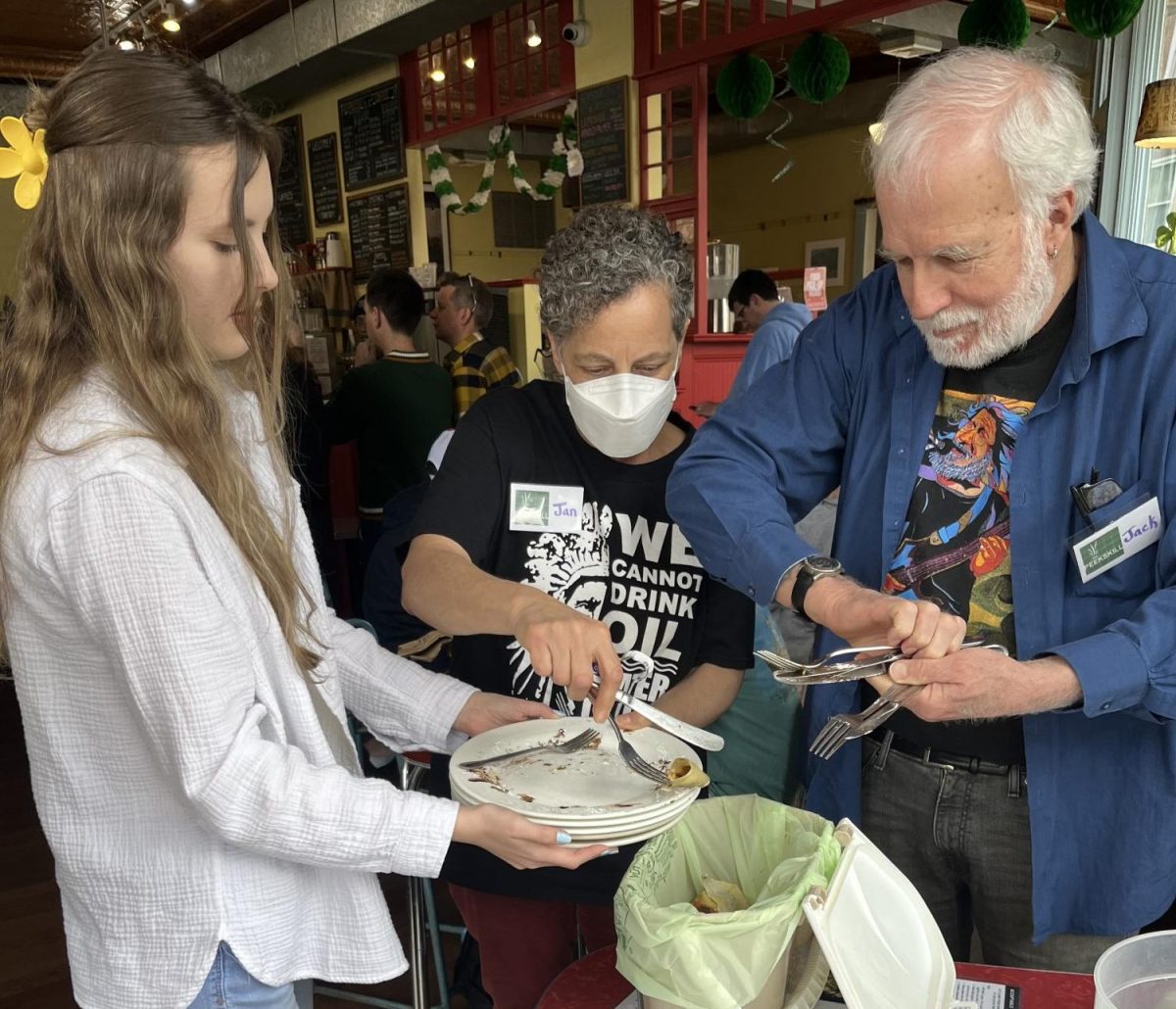 CURE100 founders Jan Melillo, center, and John Sullivan help someone compost their leftover food at the Peekskill Coffee House last Saturday. 