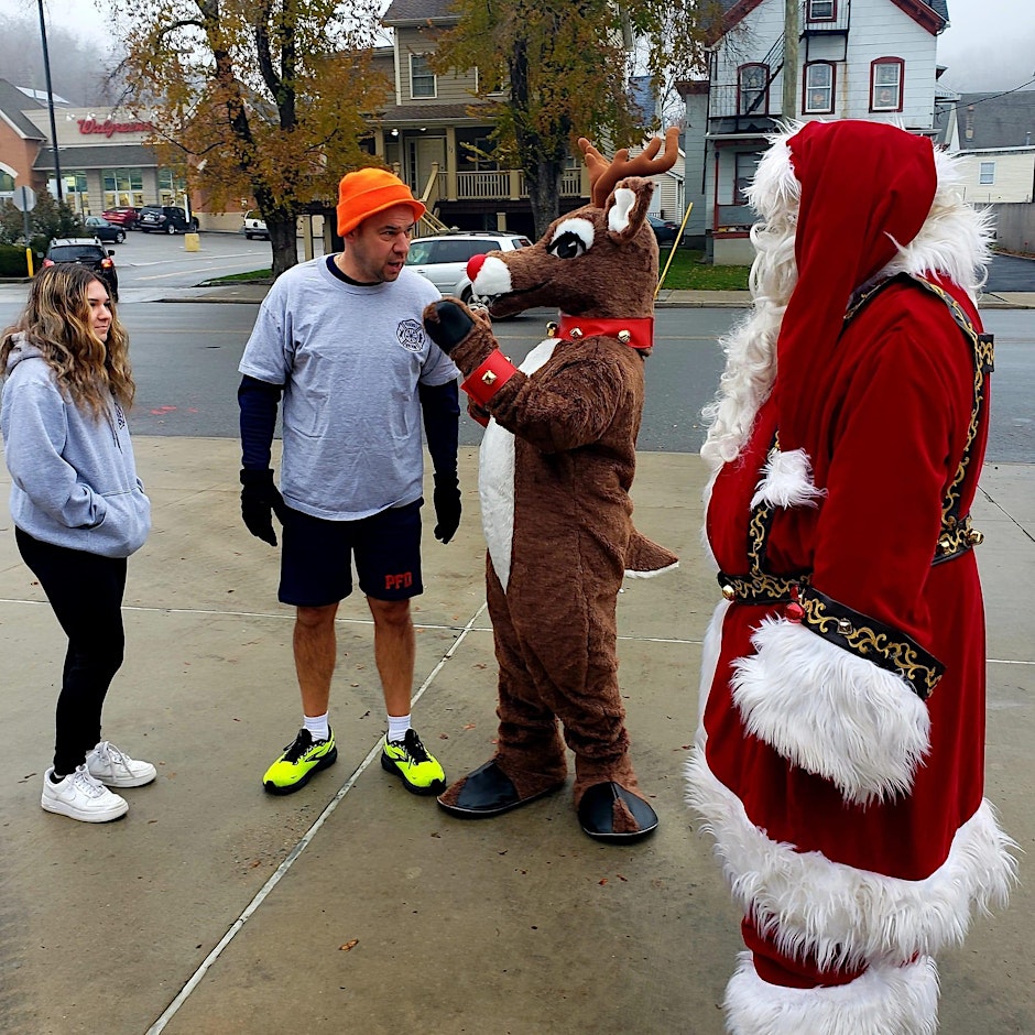 Chief Seymour of the Peekskill Fire Department letting Rudolph know he is going to win the race. Photo Courtesy: Sue Sheridan form the Peekskill St. Patricks Parade Committee