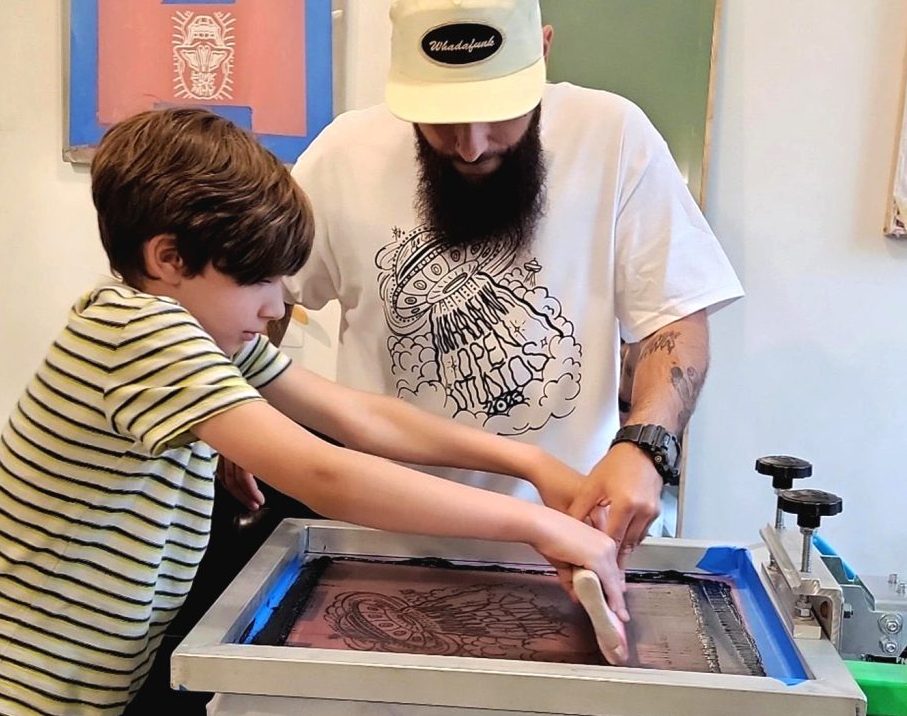 A local artist shares his creative process with a child during a previous edition of Open Studios in downtown Peekskill.