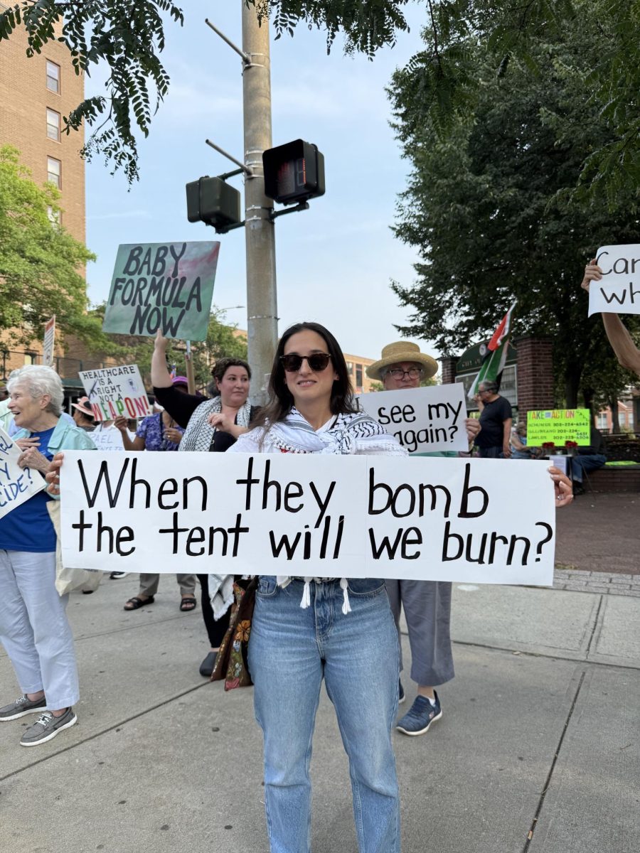 
Rawan Nahas, a Christan Palestinian residing in Croton-on-Hudson, holds a sign with a question from the children in Gaza. (Mya Guardino)