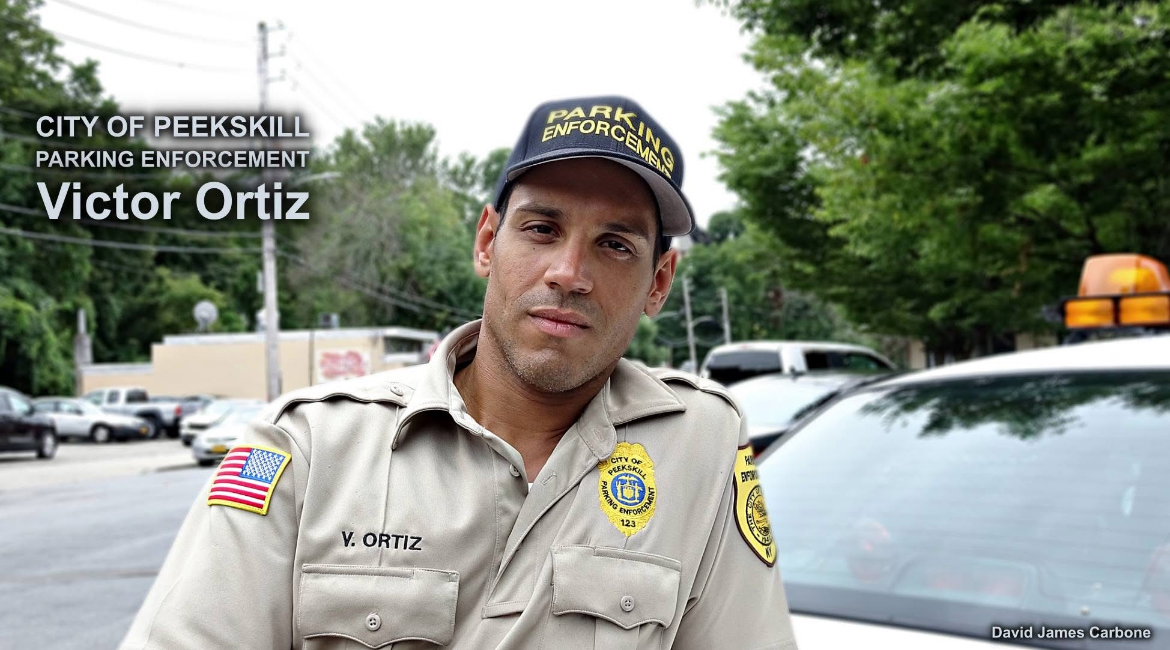 Victor Ortiz stands in front of a parking enforcement vehicle. He’s worked for the police department for over seven years. (David James Carbone)
