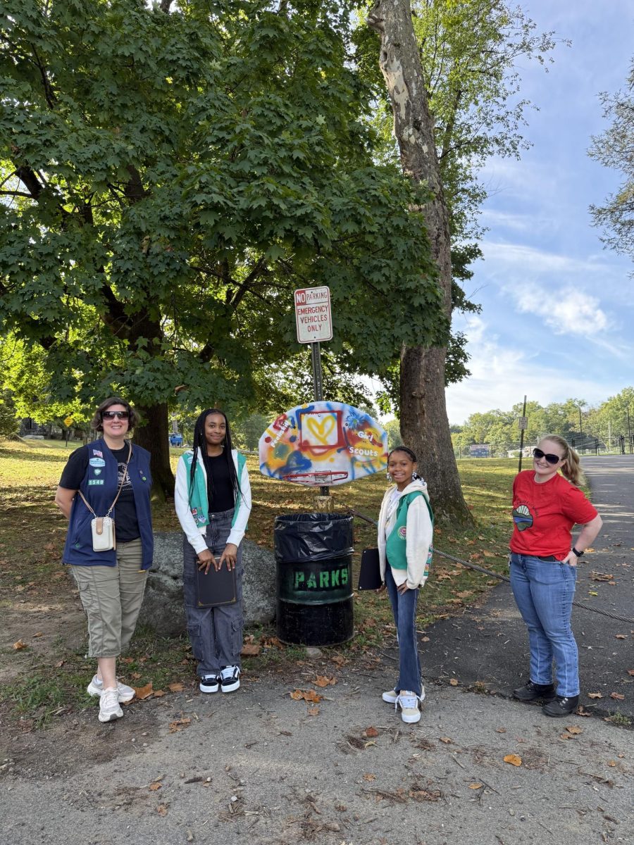 (From left) Troop Leader Sherna Safford, Troop members Assata Brown-Bey and Nia Sales, and Troop Leader Rosie Goldman at the unveiling of the "Leave No Trace Hoop" on Saturday, Sept. 27.  
