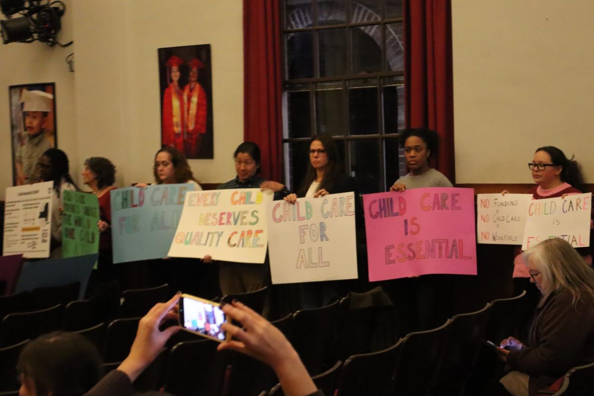 A group of attendees line up for a sign parade ahead of the meeting’s public comment portion. 