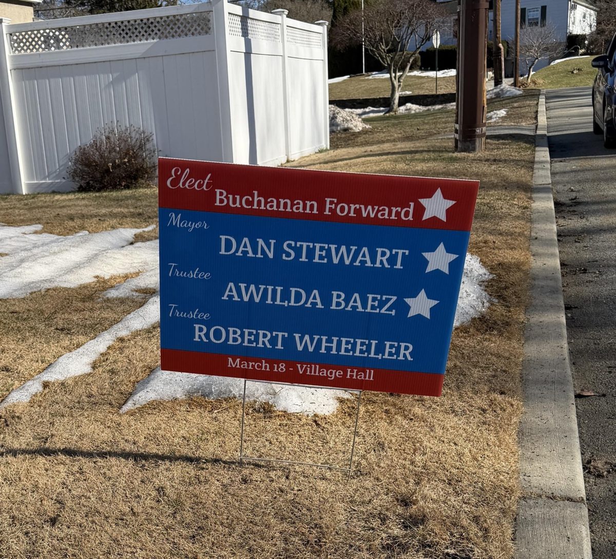 A lawn sign shows support for mayoral candidate Dan Stewart and trustee candidates Awilda Baez and Robert Wheeler.