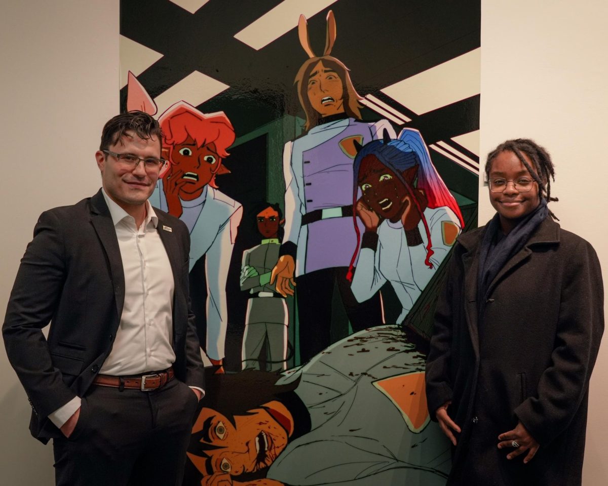 Program instructor David Abrevaya (left) poses with student Koby Clark in front of Clark’s featured exhibition piece, Cabin Fever. 